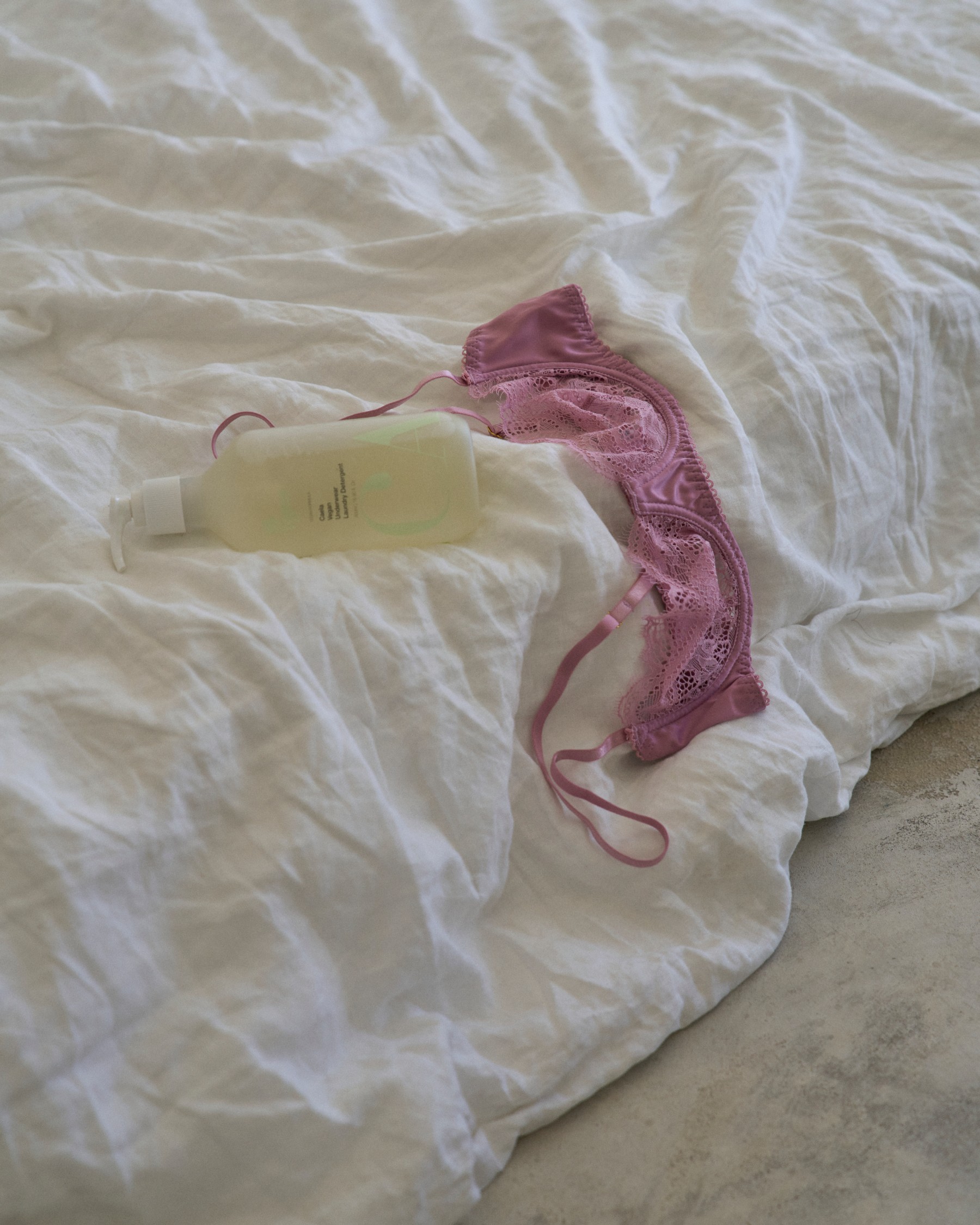 CAELA feminine care arranged on soft bedding